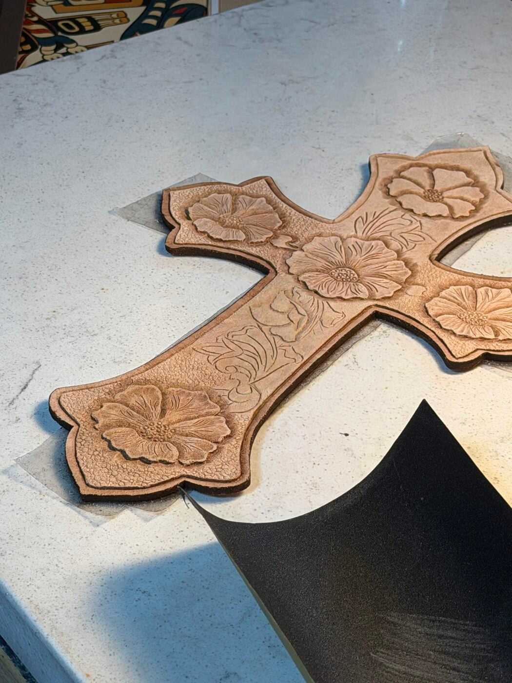 Hand-tooled leather cross with floral carving