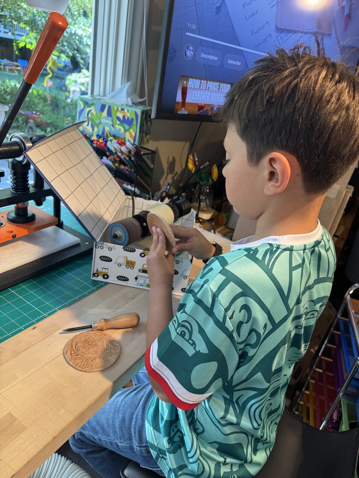 Wes carving a leather coaster at the workbench
